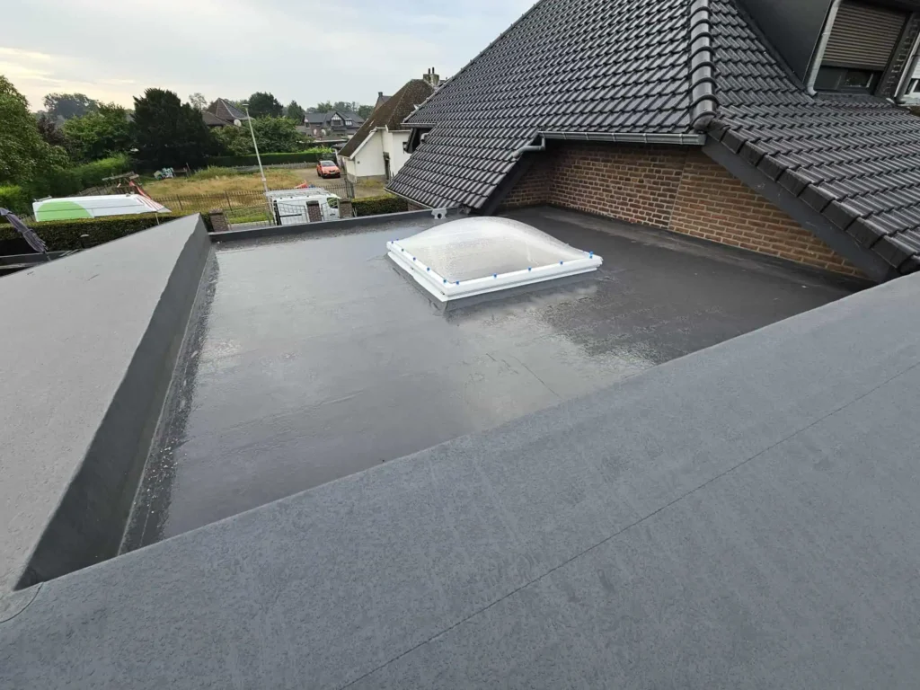 Plat dak met lichtkoepel en hellend pannendak, gerenoveerd door Dakwerken Vanderhallen